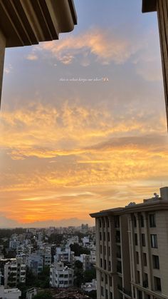 the sun is setting over a city with buildings in the foreground and clouds in the background