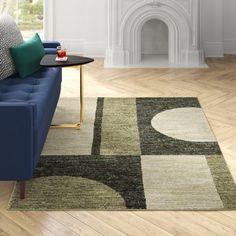 a living room with a couch, chair and rug on the wooden floor next to a fire place