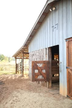 an open barn door on the side of a building with a horse in it's stall