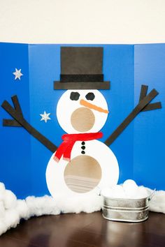 a snowman made out of toilet paper on top of a wooden floor next to a tin can