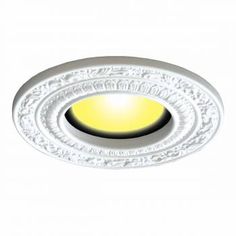 a white ceiling light with a yellow light in it's center and an ornate design