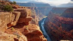 the sun shines brightly on the canyon's edge as it sits high above the water