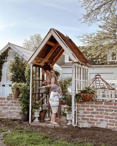 a woman standing in front of a small house