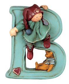 a ceramic figurine of a child on the letter b with a teddy bear