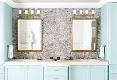 two sinks and mirrors in a bathroom with blue cabinets