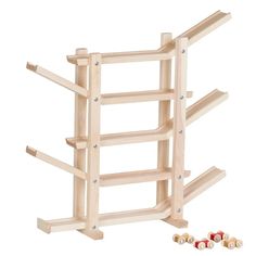 a wooden rack with four pegs in it and three small ones on the floor