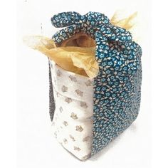 a blue and white fabric bag with yellow paper in it