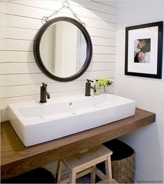 a bathroom with a sink, mirror and stool