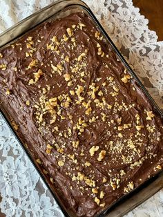 a chocolate cake with walnuts on top in a pan