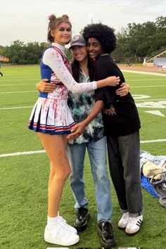 two young women hugging each other on a football field