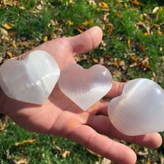 two heart shaped rocks held in someone's hand