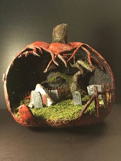 a fake pumpkin with trees and tombstones in it