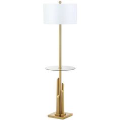 a table lamp with a white shade on it and a gold stand holding a glass plate