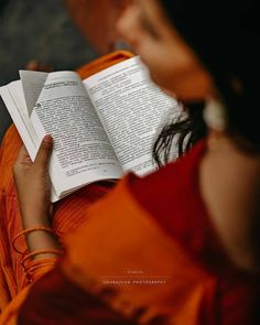 a woman reading a book while sitting down