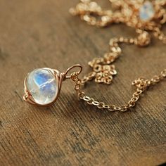 This delicate necklace features a gorgeously glowing rainbow moonstone gem wrapped in 14k rose gold fill and suspended from 14k rose gold fill chain. The natural beauty of this finely faceted stone is striking. Also available in 14k gold fill or sterling silver. Total length- 18 inches (47.5 cm) Moonstone- 9 mm See more~ Coordinating earrings- https://www.etsy.com/listing/538241519/ Gold earrings- http://www.etsy.com/shop/aubepine?section_id=6307607 The rest of my jewelry shop- http://aubepine.e Rose Gold Moonstone Jewelry With Birthstone, Rose Gold Moonstone Jewelry With Gemstone, Rose Gold Moonstone Gemstone Jewelry, Dainty Rose Gold Moonstone Jewelry, Minimalist Wire Wrapped Moonstone Jewelry, Dainty Wire Wrapped Moonstone Jewelry, Dainty Rose Gold Wire Wrapped Necklaces, Rose Gold Wire Wrapped Necklace, Elegant Hand Wrapped Moonstone Necklaces