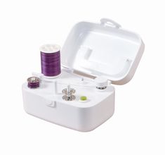 an open white box with purple thread and spools in it on a white background