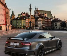 a grey car parked in front of some buildings