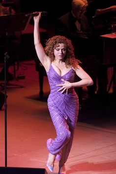 a woman in a purple dress on stage