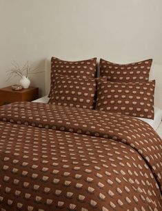 the bed is made with brown and white sheets