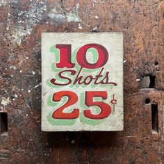 a sign on the side of a wooden door that says 10 shots, 25 cents