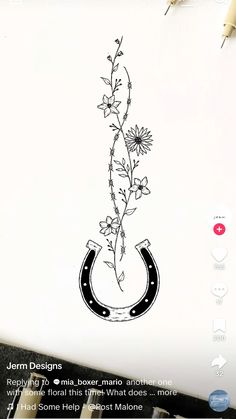 a drawing of a horse shoe with flowers in the middle and an arrow on it