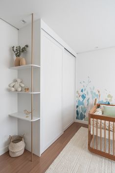 a baby's room with a crib and shelves on the wall next to it