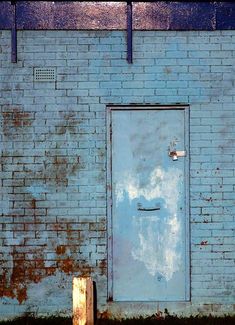 an old blue brick building with a white door