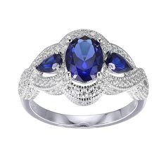 Sterling Silver Created Blue Sapphire and Cubic Zirconia Ring  Beautiful blue created sapphires paired with the diamond-like sparkle of cubic zirconia and fine, filigree accents, give this sterling silver ring the look and feel of a modern heirloom.        Measures approx. 1/2" x 13/16" x 1/4"; shank 1/16"W     Stamped .925; rhodium plating; polished finish             Stone Information       All sizes and weights approximate     Created Blue Sapphire - Oval; 1.24ct     Created Blue Sapphire - P Silver Sapphire Ring With Pear-shaped Cubic Zirconia, Pear-shaped Sapphire Ring With Cubic Zirconia For Gift, Luxury Silver Pear-shaped Sapphire Ring, Elegant Pear-shaped Sapphire Ring In Sterling Silver, Pear-shaped Sapphire Ring In Sterling Silver For Gift, Cubic Zirconia Rings, Sterling Ring, Blue Sapphire, Cubic Zirconia