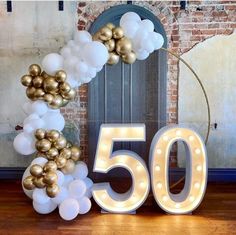 a 50th birthday decoration with balloons and lights