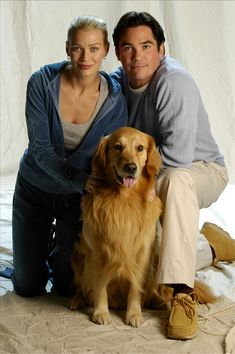 a man and woman pose for a photo with their dog