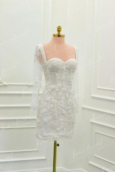 a white dress on a mannequin in front of a wall