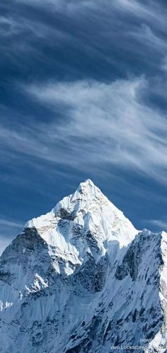 a snow covered mountain under a cloudy blue sky