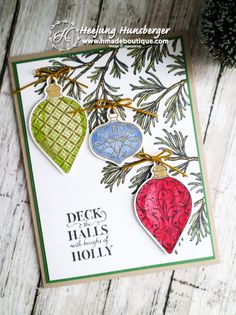 a christmas card with three ornaments hanging from it