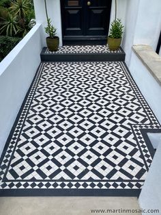 a black and white tiled entrance with potted plants