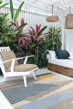 a white chair sitting on top of a rug next to a bed