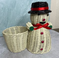 a wicker snowman sitting next to two baskets