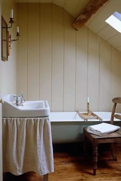 an old fashioned bathtub in the corner of a bathroom next to a wooden chair