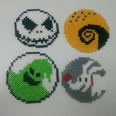 four different types of bead coasters on a table with one being a skull, the other is an alien