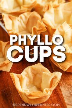 the words phylo cups are in front of some dumplings on a wooden table