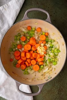 carrots, celery and onions are mixed together in a pot