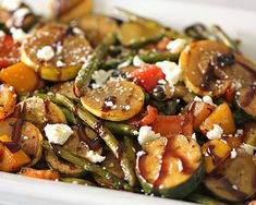 a white dish filled with vegetables covered in cheese