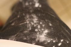 a close up view of the back end of a black and white cat with spots on it's fur