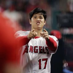 a baseball player is holding his hand out to the side while standing in front of other players