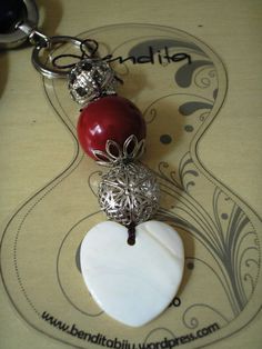 a red and white heart shaped keychain sitting on top of a table