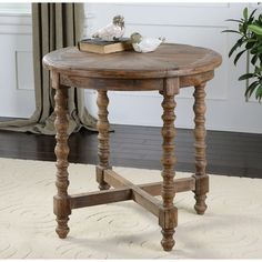 a small wooden table sitting on top of a white floor next to a potted plant