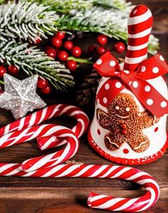 christmas decorations with candy canes and gingerbread on wooden table in front of fir tree