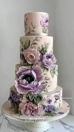 a three tiered cake with purple flowers on it