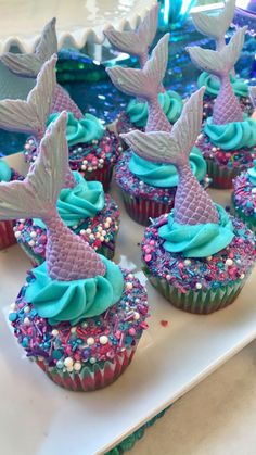 cupcakes with blue frosting and mermaid tail decorations