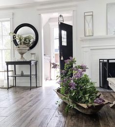 a living room filled with furniture and a fire place next to a fireplace covered in plants