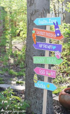 a wooden sign with many different colored signs on it's side next to a tree